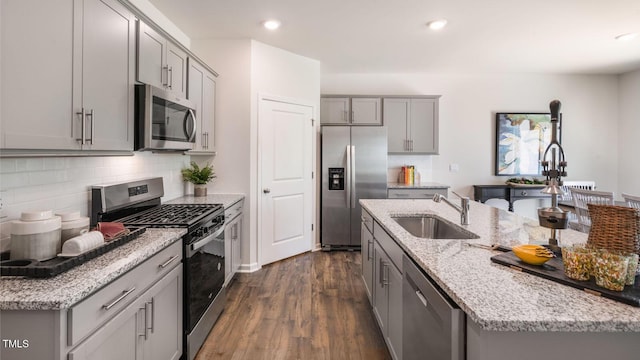 kitchen featuring dark wood finished floors, stainless steel appliances, gray cabinetry, a sink, and recessed lighting