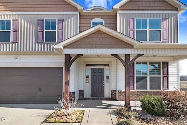 property entrance with covered porch, driveway, board and batten siding, and an attached garage