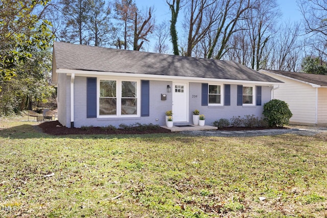 ranch-style house with brick siding, roof with shingles, and a front yard