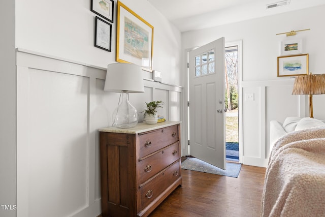 foyer entrance with dark wood-type flooring and visible vents