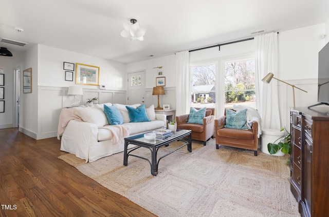 living area with visible vents and wood finished floors