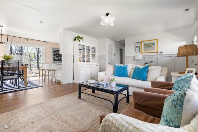 living room with wainscoting and wood finished floors