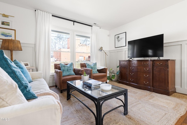 living room with wainscoting and a decorative wall