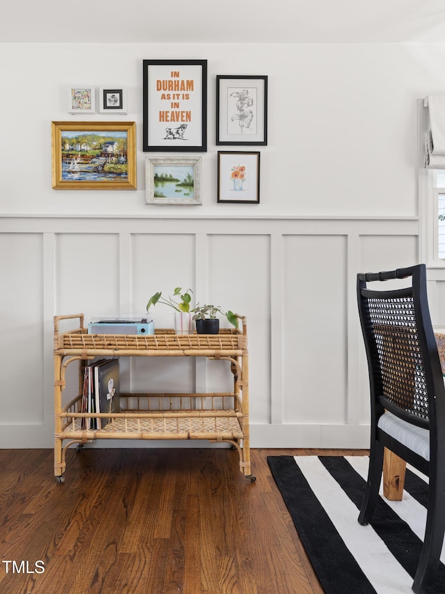 sitting room featuring a decorative wall and wood finished floors