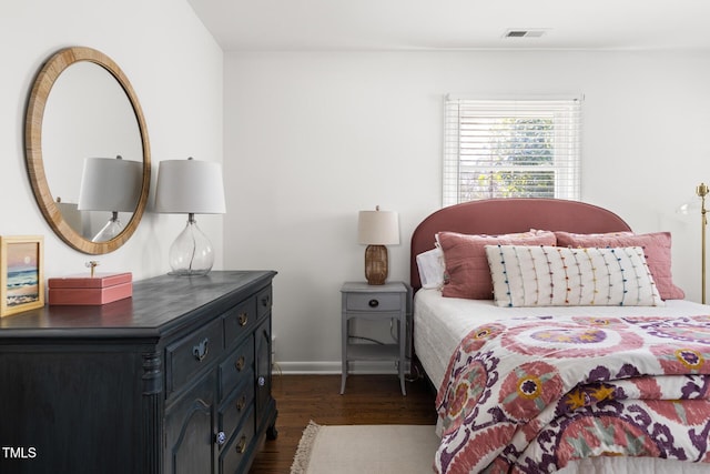 bedroom with dark wood-type flooring and visible vents