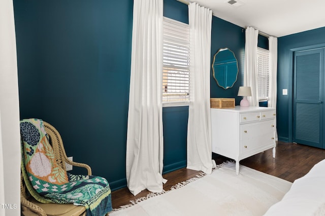 bedroom with dark wood-type flooring, visible vents, and baseboards