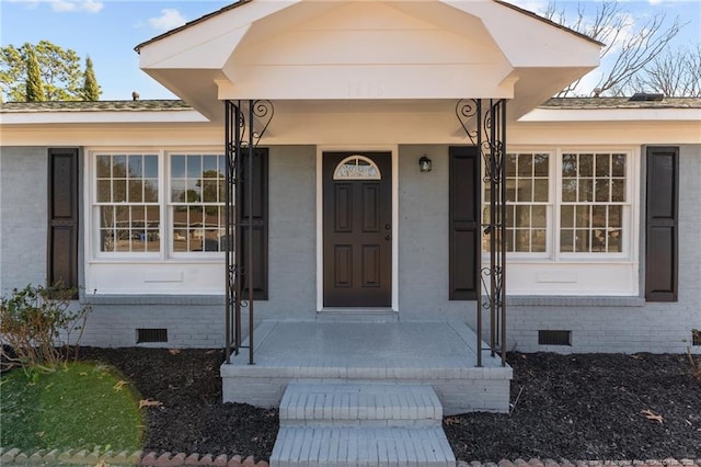 entrance to property featuring brick siding and crawl space