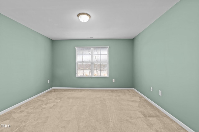 spare room featuring carpet floors and baseboards