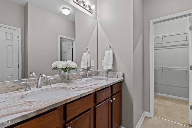 full bathroom with a sink, a spacious closet, and double vanity