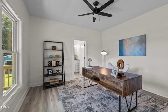 office area featuring a ceiling fan, light wood-style flooring, and baseboards