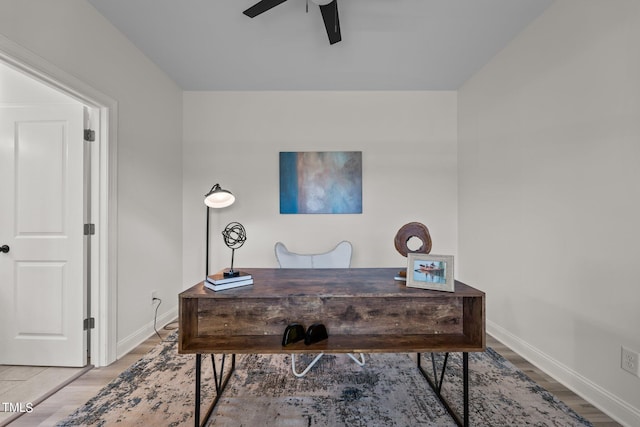 office area with a ceiling fan, baseboards, and wood finished floors