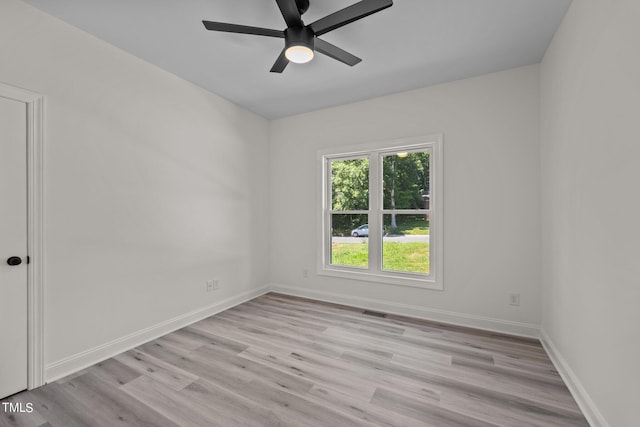 empty room featuring light wood-style flooring, visible vents, baseboards, and ceiling fan