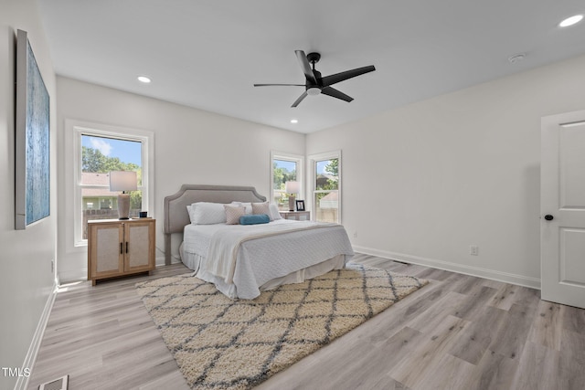 bedroom with light wood-type flooring, multiple windows, and recessed lighting