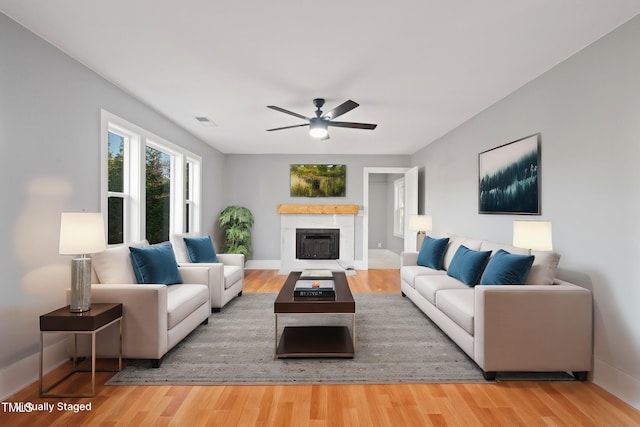 living area with visible vents, a fireplace, and wood finished floors