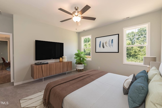 carpeted bedroom with baseboards, ceiling fan, and visible vents