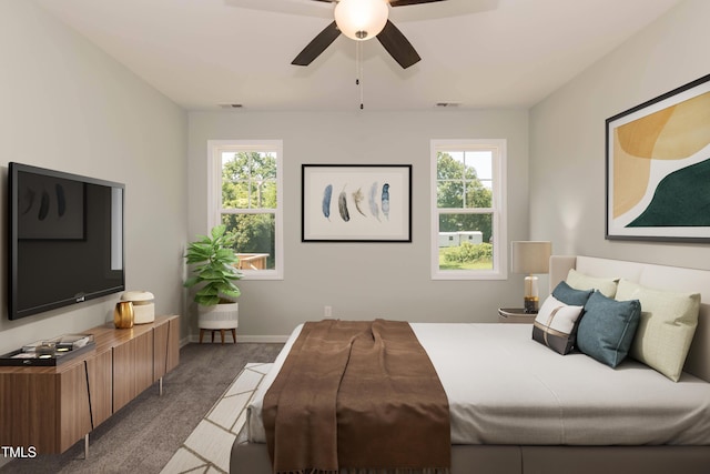 carpeted bedroom with visible vents, baseboards, ceiling fan, and multiple windows