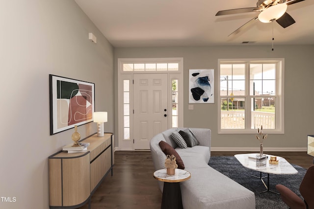 living room featuring baseboards, a ceiling fan, dark wood-style flooring, and visible vents