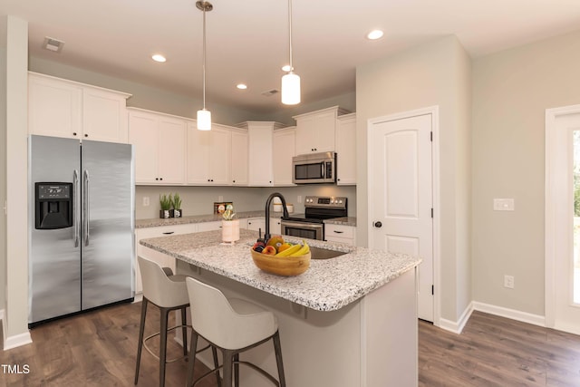 kitchen with visible vents, a center island with sink, dark wood-type flooring, white cabinetry, and stainless steel appliances