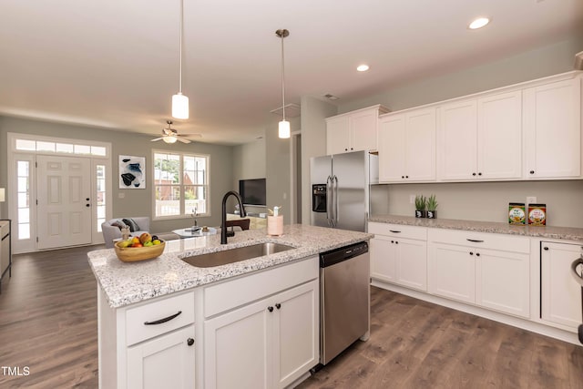 kitchen with ceiling fan, a sink, stainless steel appliances, open floor plan, and white cabinetry