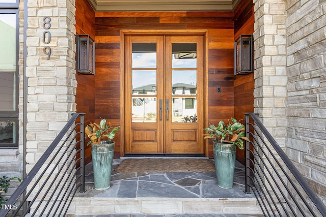 doorway to property featuring stone siding and french doors