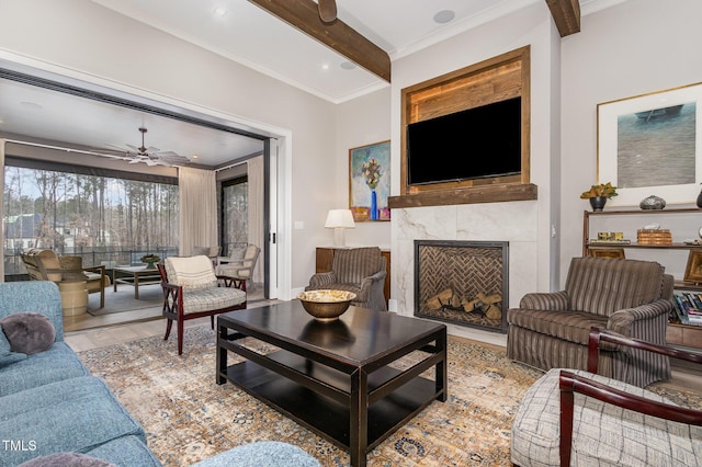 living room featuring a ceiling fan, wood finished floors, beamed ceiling, crown molding, and a fireplace