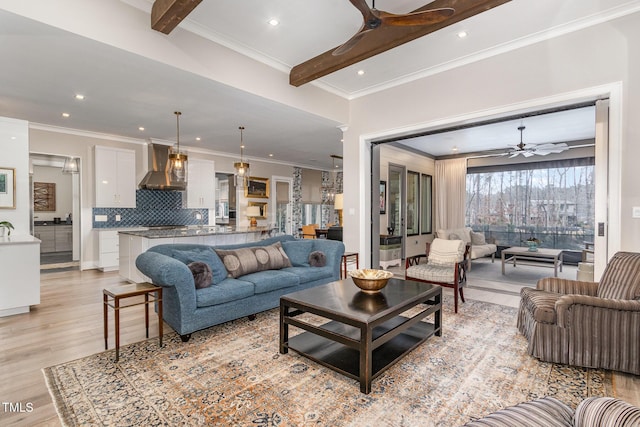 living area with light wood-style floors, beam ceiling, crown molding, and ceiling fan