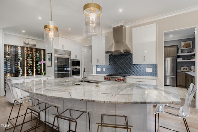 kitchen featuring ornamental molding, a sink, stainless steel appliances, wall chimney range hood, and backsplash