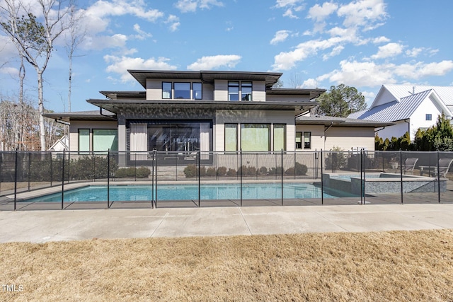 view of swimming pool featuring a patio, a lawn, fence, and a pool with connected hot tub