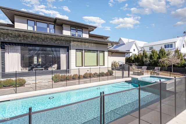 view of pool featuring a patio area, a pool with connected hot tub, and fence