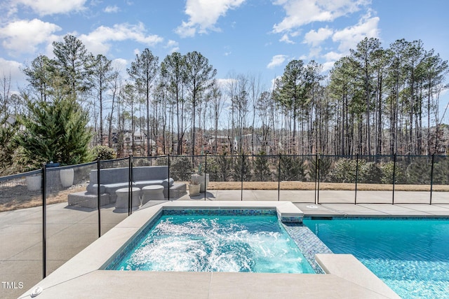 view of pool with an in ground hot tub, a patio area, fence, and a fenced in pool