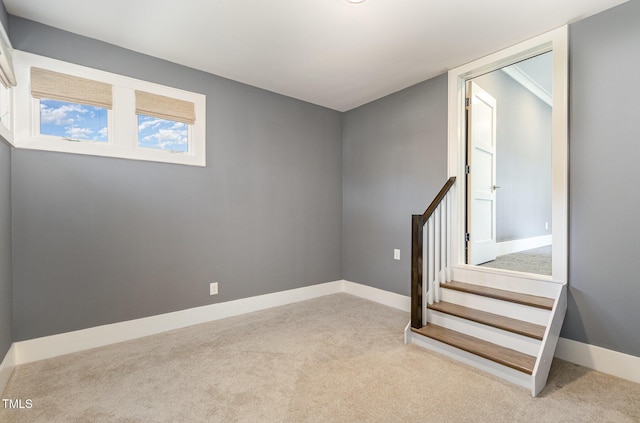 unfurnished room with carpet floors, stairway, and baseboards