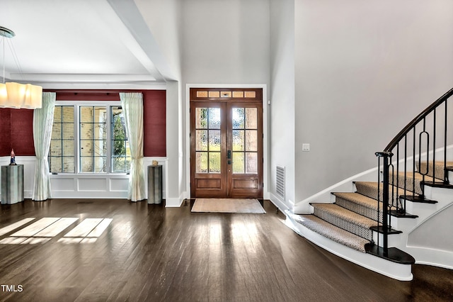 entrance foyer featuring visible vents, wainscoting, hardwood / wood-style floors, stairs, and french doors