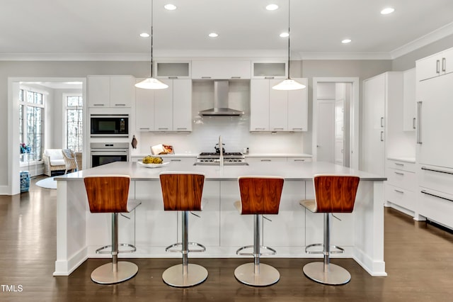 kitchen featuring modern cabinets, ornamental molding, dark wood-style flooring, built in appliances, and wall chimney range hood