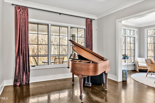 sitting room with ornamental molding, hardwood / wood-style floors, visible vents, and baseboards