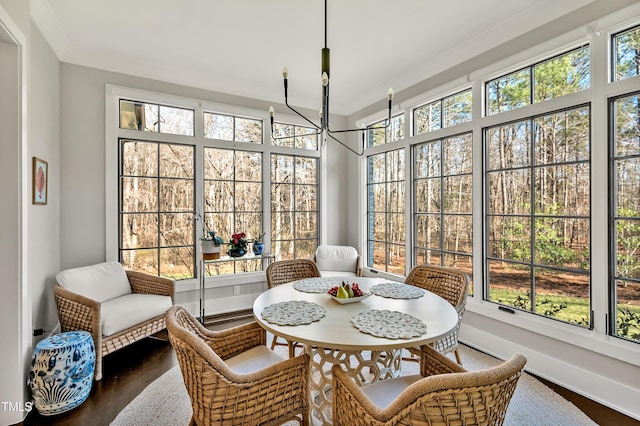 sunroom with plenty of natural light and a notable chandelier