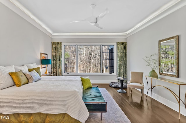 bedroom featuring multiple windows, wood finished floors, and baseboards