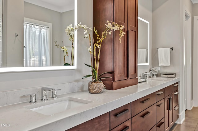 bathroom featuring double vanity, tile patterned flooring, and a sink