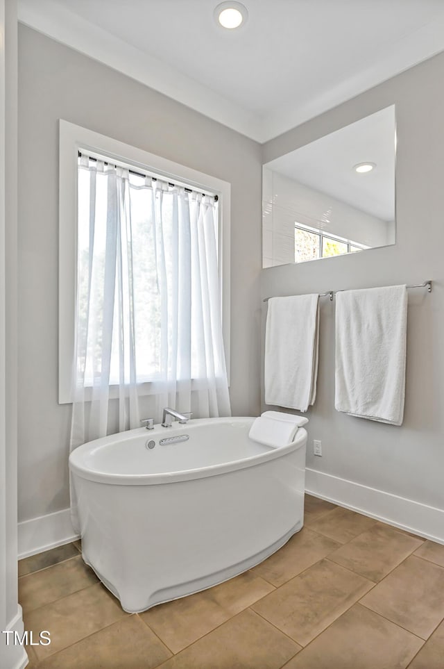 bathroom with recessed lighting, a freestanding bath, baseboards, and tile patterned floors