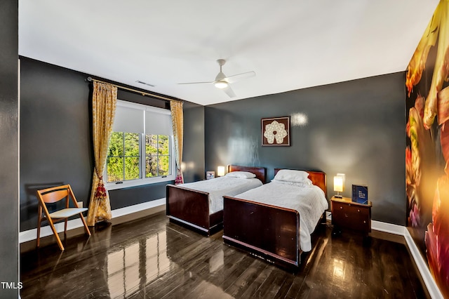 bedroom with a ceiling fan, wood finished floors, visible vents, and baseboards