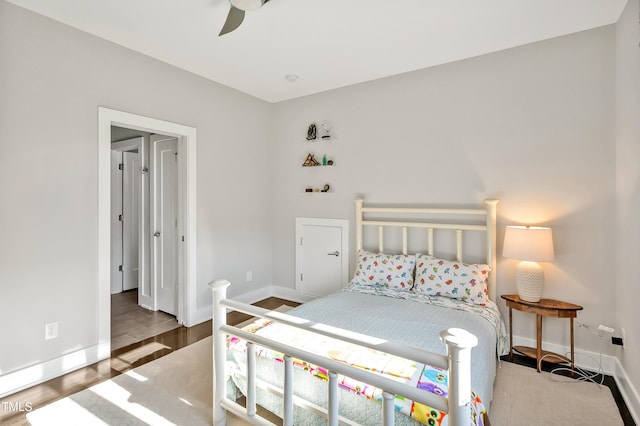 bedroom featuring wood finished floors, a ceiling fan, and baseboards