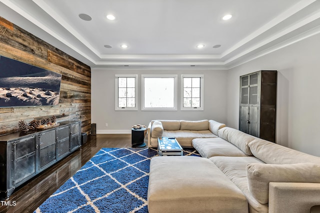 living area with wooden walls, a raised ceiling, wood finished floors, and recessed lighting