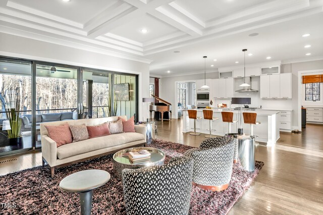 living area with crown molding, coffered ceiling, beam ceiling, and a healthy amount of sunlight