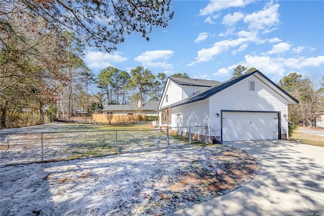 view of home's exterior with a garage, driveway, and fence