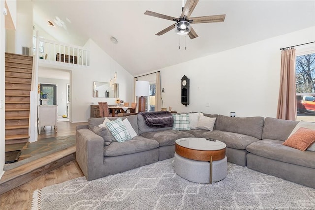 living area featuring ceiling fan, high vaulted ceiling, stairway, and wood finished floors