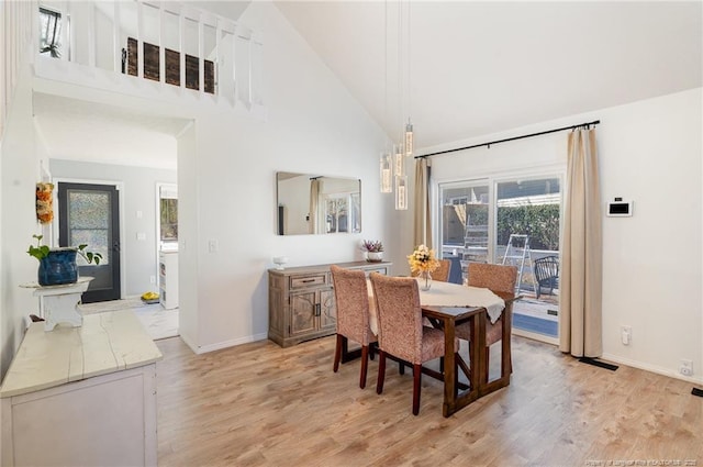 dining space with high vaulted ceiling, visible vents, light wood-style flooring, and baseboards