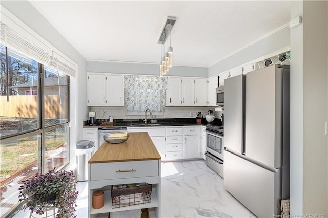 kitchen featuring marble finish floor, stainless steel appliances, backsplash, white cabinetry, and a sink