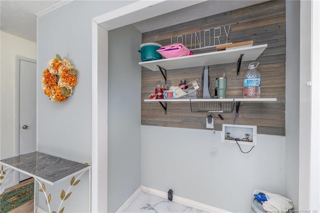 laundry area featuring marble finish floor, hookup for a washing machine, wooden walls, laundry area, and baseboards