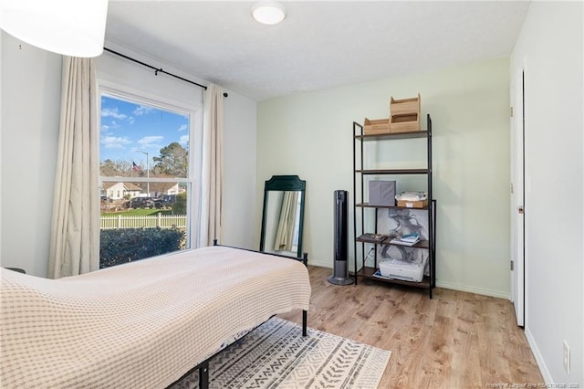 bedroom with baseboards and light wood finished floors