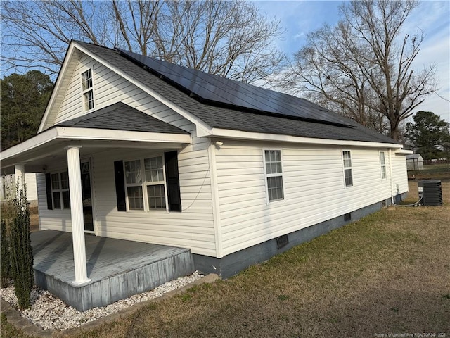 view of property exterior with a shingled roof, solar panels, a lawn, crawl space, and central AC