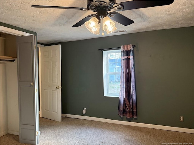 unfurnished bedroom with a textured ceiling, light carpet, visible vents, and baseboards